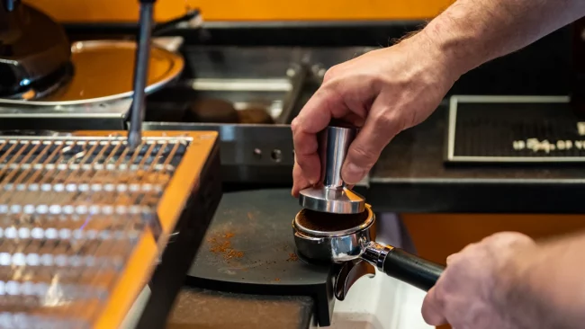 Making coffee at North Coast Café in Lynton, reflecting on over 16,000 coffees made since opening in 2022